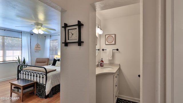 bathroom with ceiling fan, vanity, and wood-type flooring