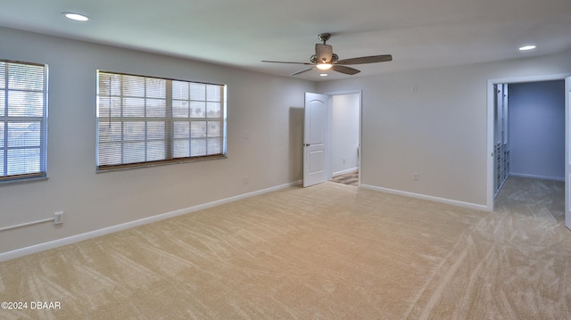 unfurnished bedroom featuring ceiling fan, light colored carpet, and multiple windows