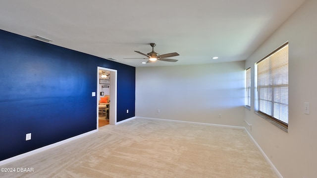 empty room with ceiling fan and light carpet