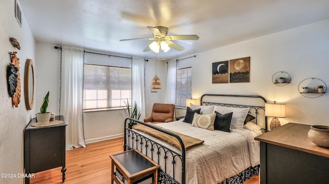 bedroom with light hardwood / wood-style flooring and ceiling fan