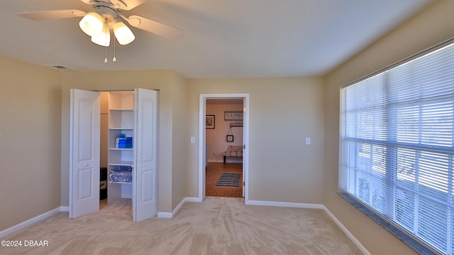 unfurnished bedroom with ceiling fan, light colored carpet, and a closet