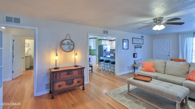 living room featuring ceiling fan and light hardwood / wood-style flooring