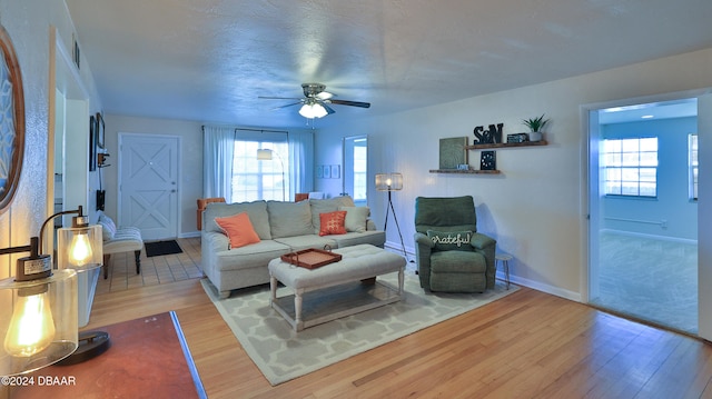 living room with a wealth of natural light, ceiling fan, a textured ceiling, and hardwood / wood-style flooring