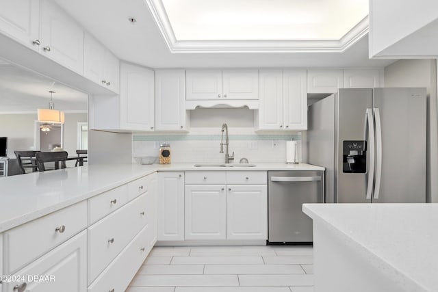 kitchen featuring a sink, tasteful backsplash, appliances with stainless steel finishes, white cabinets, and crown molding