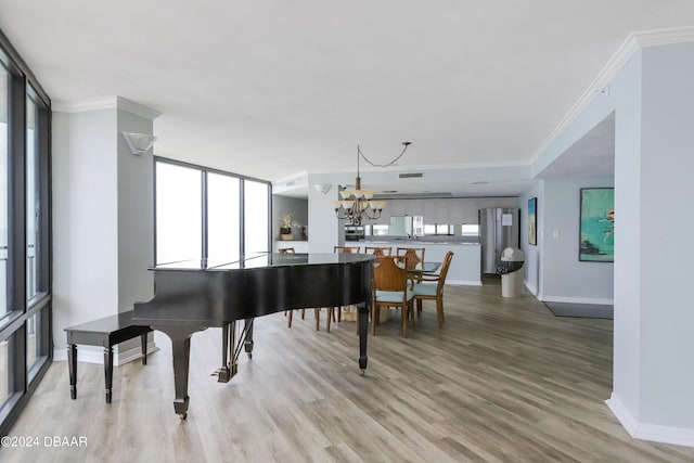 interior space featuring light wood-style floors, plenty of natural light, a notable chandelier, and crown molding