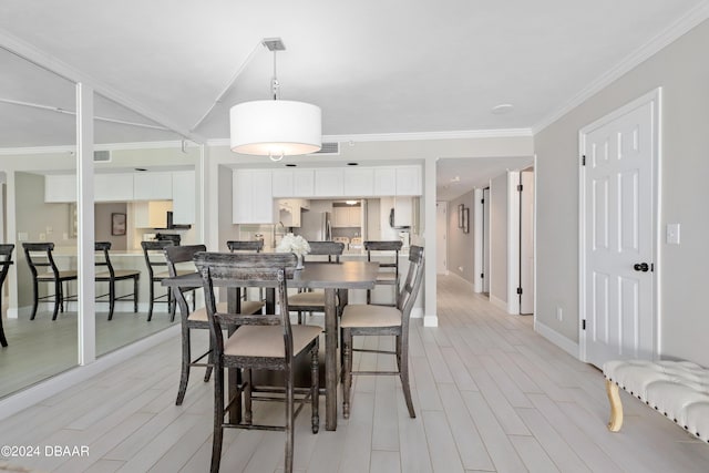 dining area with visible vents, light wood-style flooring, crown molding, and baseboards