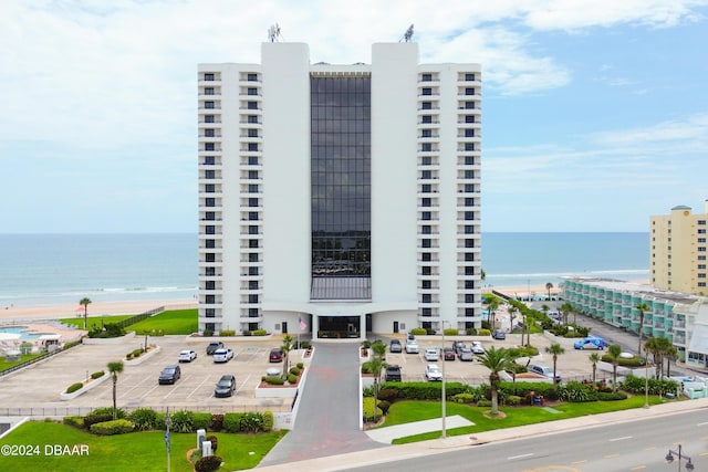 view of building exterior featuring uncovered parking and a water view