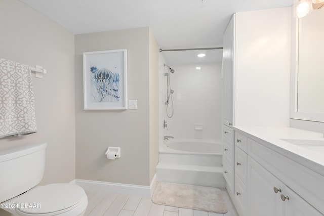 bathroom with vanity, toilet, washtub / shower combination, and baseboards