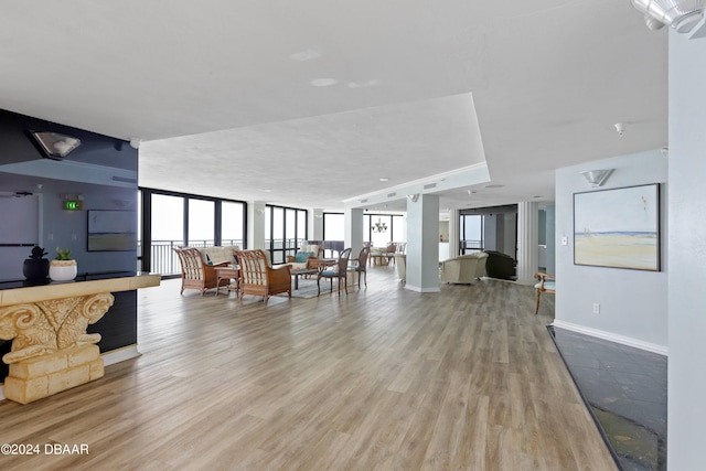 living room featuring light wood-style flooring, baseboards, and expansive windows