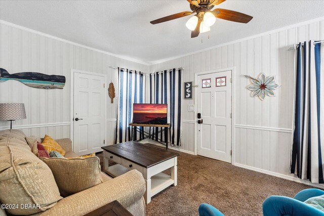 carpeted living room featuring a textured ceiling, ceiling fan, and crown molding