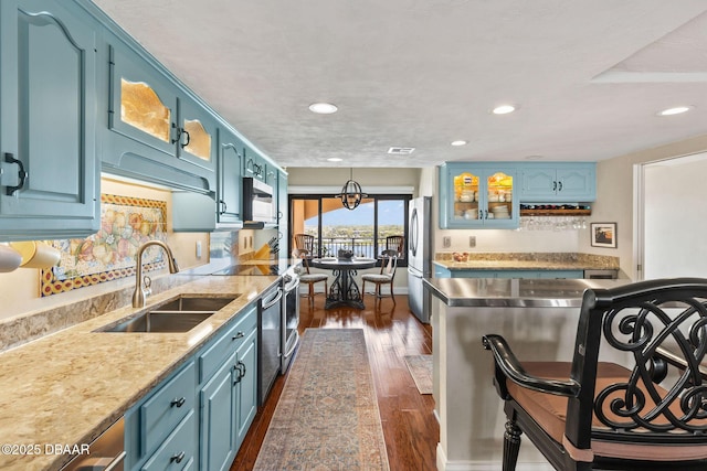 761 Marina Point Dr Unit 7610, Daytona Beach, FL 32114 - kitchen with glass insert cabinets, blue cabinetry, dark wood-type flooring, appliances with stainless steel finishes, and a sink
