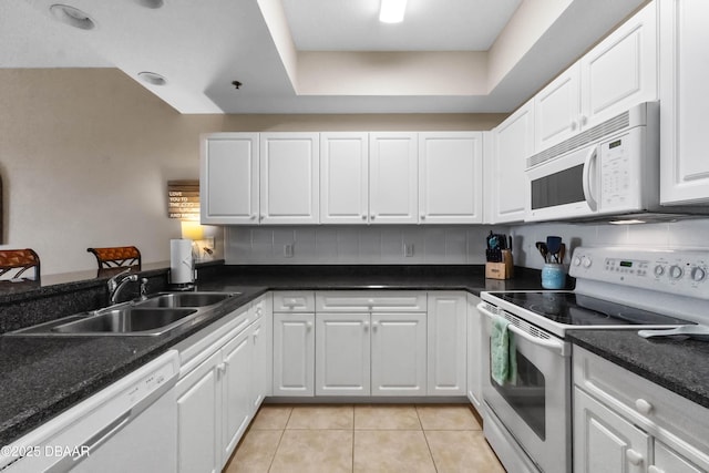 5300 S Atlantic Ave Unit 16-505, New Smyrna Beach, FL 32169 - kitchen featuring light tile patterned floors, a sink, white cabinetry, white appliances, and decorative backsplash