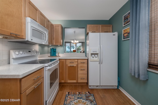 3370 Ocean Shore Blvd Unit 202B, Ormond Beach, FL 32176 - kitchen with white appliances, light wood-style floors, light countertops, and decorative backsplash