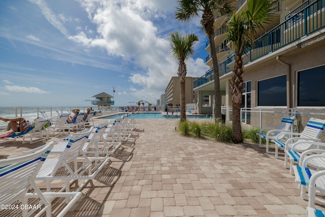 view of swimming pool featuring a water view and a patio