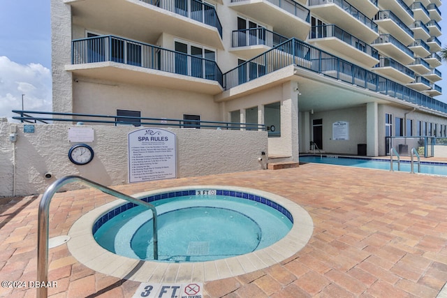 view of swimming pool featuring a community hot tub