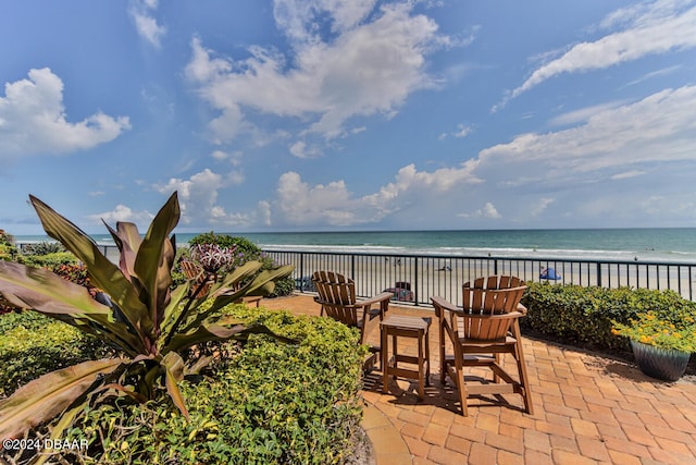 view of patio with a water view and a view of the beach