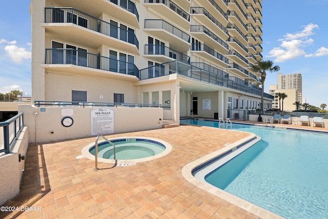 view of swimming pool with a community hot tub and a patio