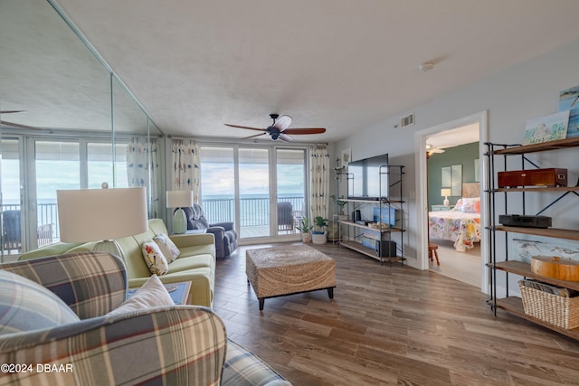 living room with expansive windows, hardwood / wood-style flooring, and ceiling fan