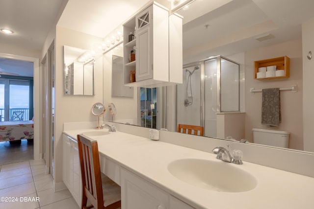 bathroom with toilet, vanity, tile patterned floors, and a shower with door