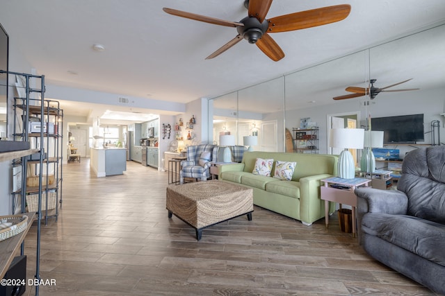 living room with wood-type flooring and ceiling fan