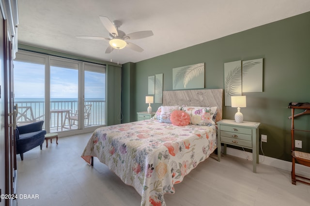 bedroom featuring a water view and ceiling fan