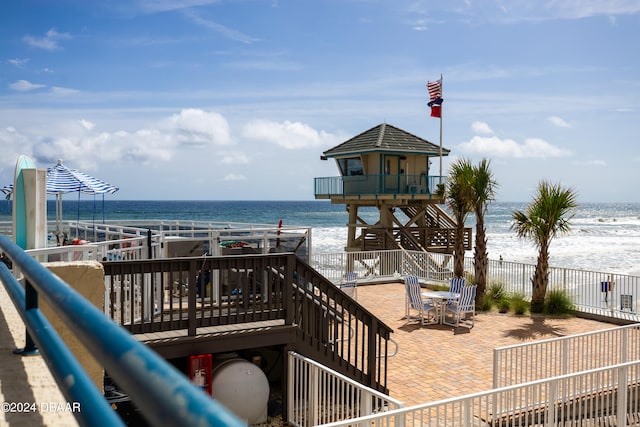 view of community with a beach view and a water view