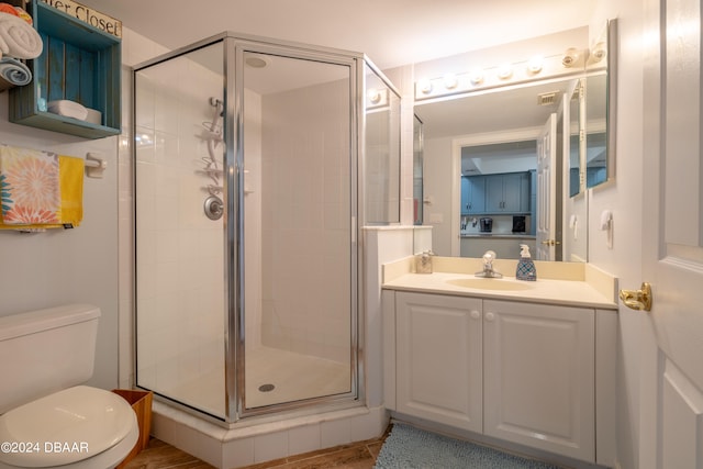 bathroom with toilet, vanity, and an enclosed shower