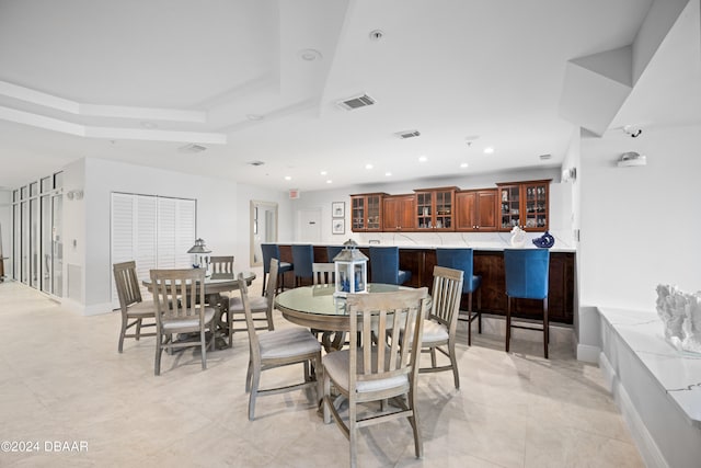 dining area with light tile patterned flooring and a tray ceiling