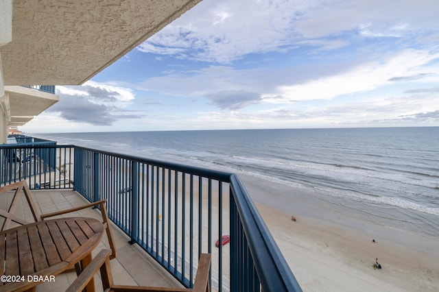 balcony featuring a water view and a beach view