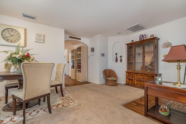 dining room featuring carpet flooring and a textured ceiling