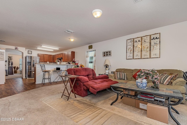 living room featuring a textured ceiling and parquet flooring