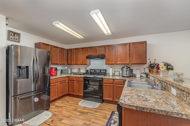 kitchen featuring sink, appliances with stainless steel finishes, light hardwood / wood-style flooring, and kitchen peninsula