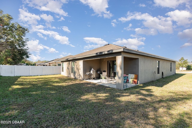 back of property with a patio area and a lawn