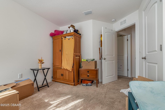 bedroom with a textured ceiling and light carpet