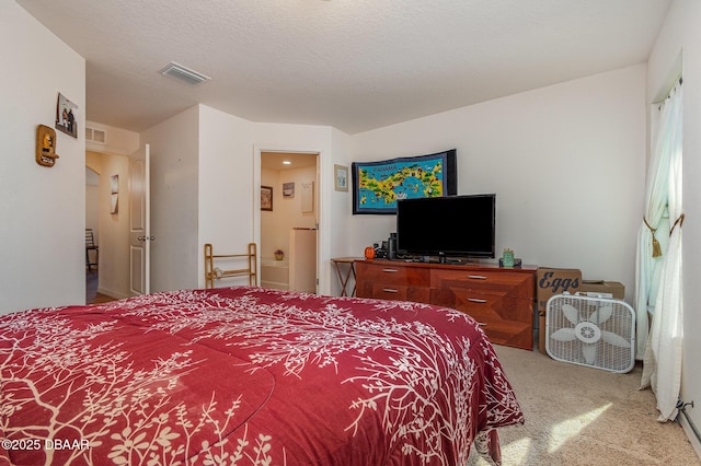 bedroom featuring a textured ceiling and light carpet