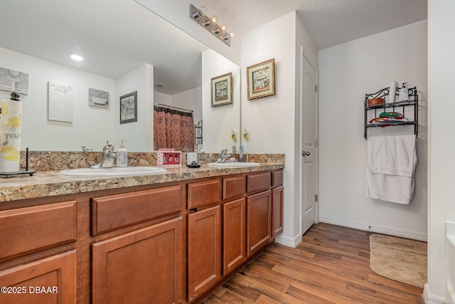 bathroom featuring vanity, curtained shower, a textured ceiling, and wood-type flooring