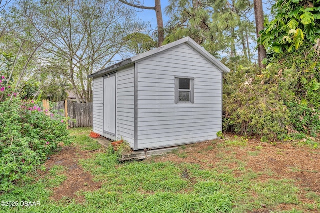 view of shed featuring fence