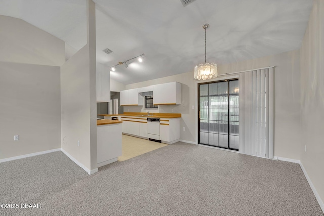 kitchen with light carpet, dishwasher, white cabinetry, and lofted ceiling