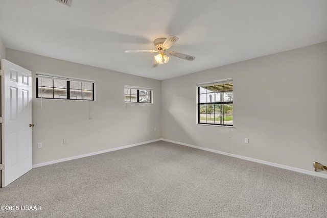 carpeted spare room featuring baseboards and ceiling fan