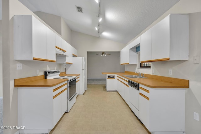 kitchen featuring white appliances, lofted ceiling, a sink, white cabinets, and under cabinet range hood