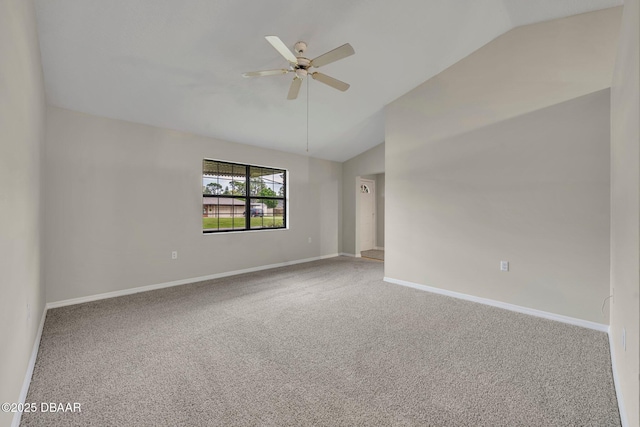 carpeted spare room featuring baseboards, a ceiling fan, and vaulted ceiling