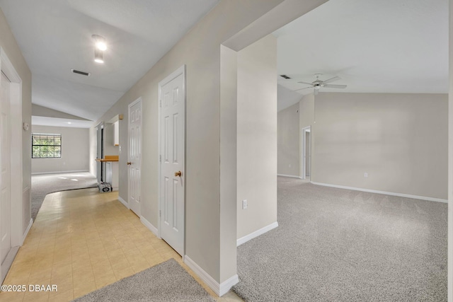 corridor featuring light colored carpet, baseboards, and lofted ceiling