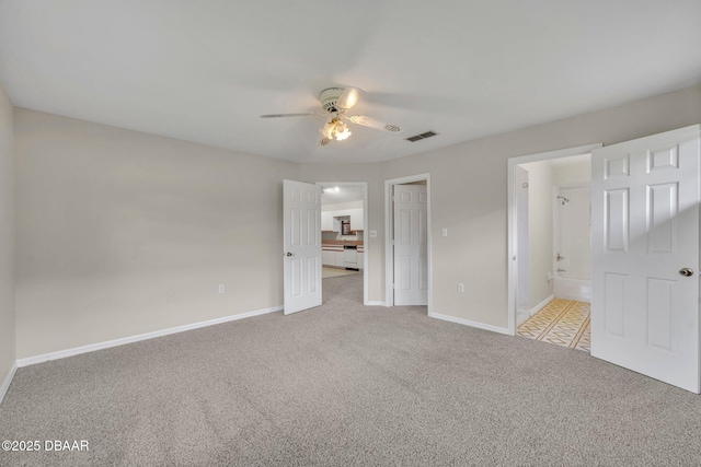 unfurnished bedroom featuring carpet flooring, baseboards, ensuite bathroom, and visible vents