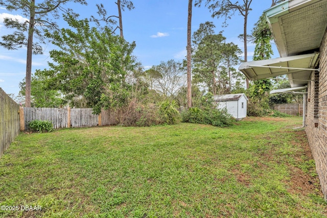 view of yard featuring a storage unit, a fenced backyard, and an outdoor structure