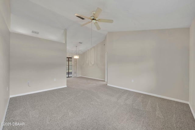 empty room featuring visible vents, lofted ceiling, ceiling fan with notable chandelier, carpet floors, and baseboards