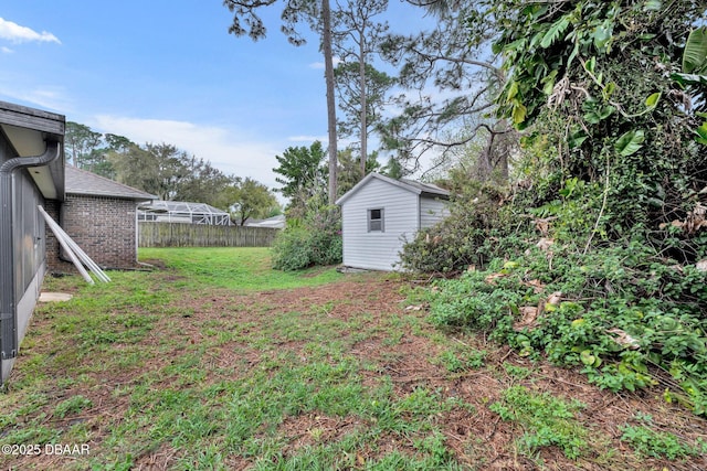 view of yard with an outbuilding, a storage shed, and fence