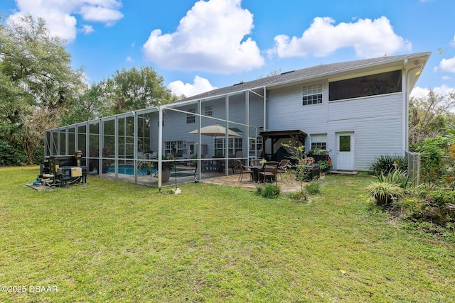 rear view of property featuring a yard, a patio, and glass enclosure