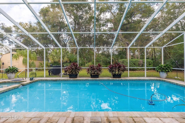 view of pool with an in ground hot tub and a lanai