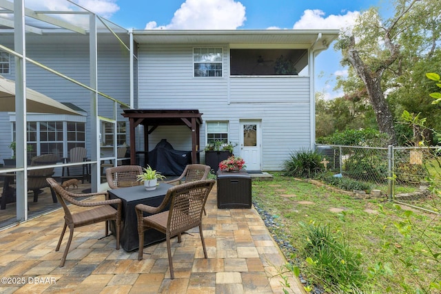 back of house with a patio and glass enclosure