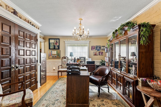 office featuring crown molding, light hardwood / wood-style flooring, a chandelier, and a textured ceiling